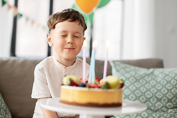 Image showing little boy with birthday cake making wish