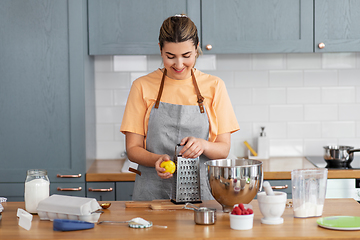 Image showing happy young woman cooking food on kitchen at home