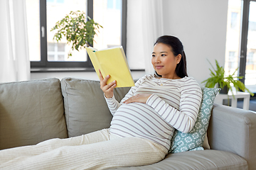 Image showing happy pregnant woman reading book at home