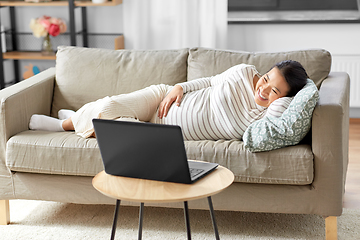 Image showing happy pregnant asian woman with laptop at home