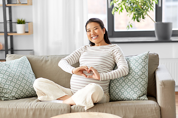 Image showing happy pregnant asian woman showing heart gesture