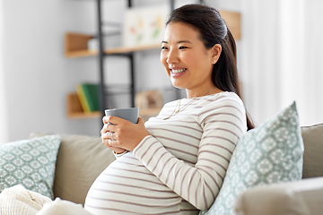 Image showing happy pregnant woman drinking tea at home