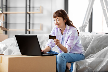 Image showing woman with laptop and credit card at new home