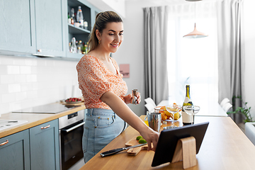 Image showing woman with tablet pc making cocktails at kitchen