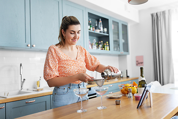 Image showing woman with tablet pc making cocktails at kitchen