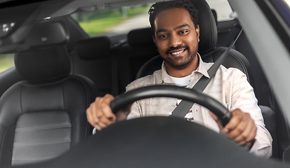 Image showing smiling indian man or driver driving car