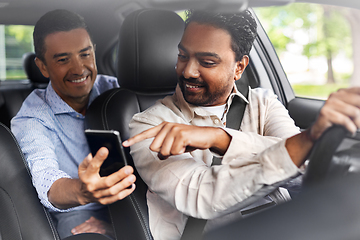 Image showing male passenger showing smartphone to car driver