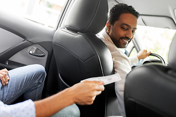 Image showing passenger giving money to smiling taxi car driver