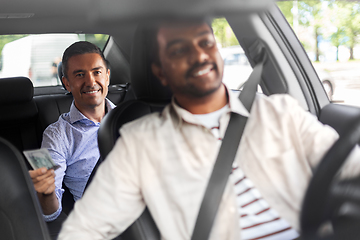 Image showing smiling passenger giving money to taxi car driver