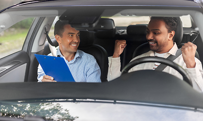 Image showing smiling car driving school instructor and driver