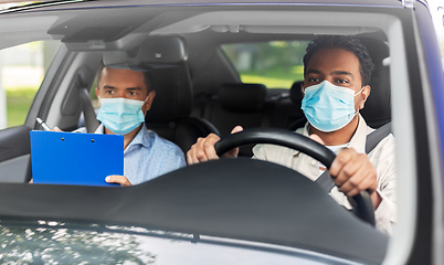 Image showing car driving school instructor and driver in mask