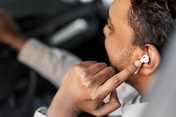 Image showing man or driver with wireless earphones driving car