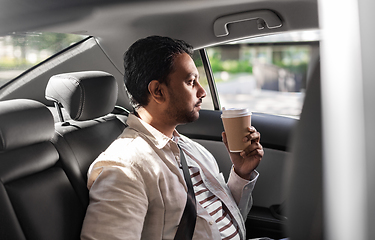 Image showing indian man with takeaway coffee on car back seat