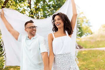 Image showing happy couple with picnic blanket at summer park