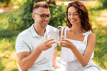 Image showing happy couple toasting drinks at summer park