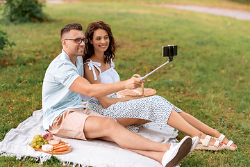 Image showing happy couple taking selfie at picnic in park