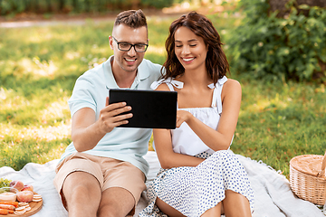 Image showing happy couple with tablet pc at picnic in park