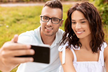 Image showing happy couple taking selfie at summer park
