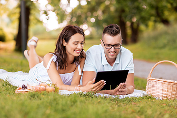 Image showing happy couple with tablet pc at picnic in park