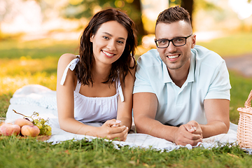 Image showing happy couple on picnic blanket at summer park