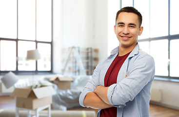 Image showing smiling young man over new home background