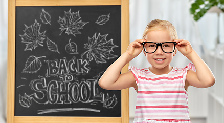 Image showing little student girl in glasses over chalkboard