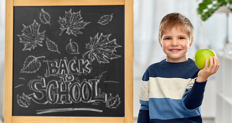 Image showing little student boy with apple at school blackboard