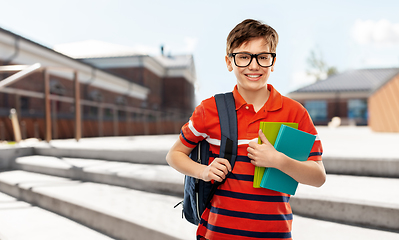 Image showing smiling student boy with backpack and books