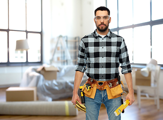 Image showing male builder with tools and level at home