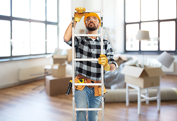 Image showing male builder in helmet climbing up ladder at home