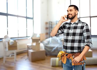 Image showing builder in helmet calling on smartphone at home