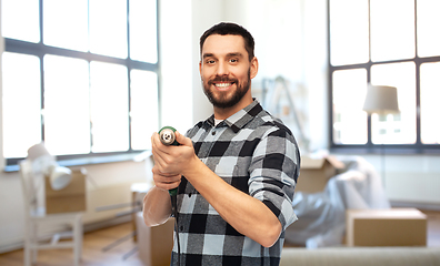 Image showing happy man, worker or builder with drill at home