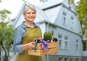 Image showing smiling senior woman with garden tools in box