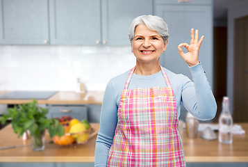 Image showing smiling senior woman in apron showing ok gesture