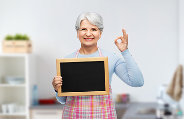 Image showing senior woman in apron with chalkboard showing ok