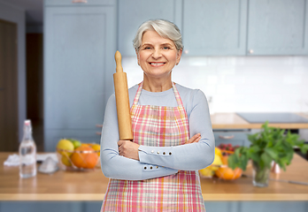 Image showing smiling senior woman in apron with rolling pin