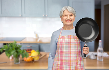 Image showing smiling senior woman in apron with frying pan