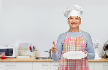 Image showing smiling senior woman or chef holding empty plate