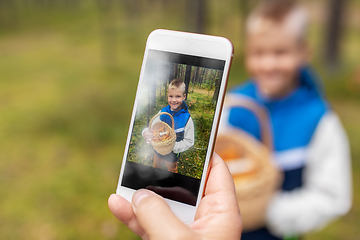 Image showing parent photographing grandson with mushrooms