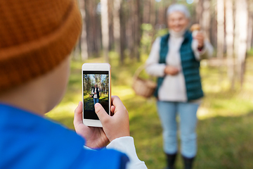 Image showing grandson photographing grandmother with mushroom