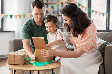 Image showing happy family opening birthday presents at home