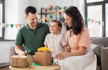 Image showing happy family opening birthday presents at home