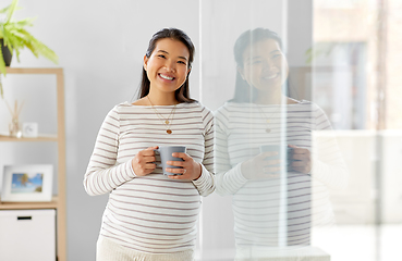 Image showing happy pregnant woman drinking tea at home