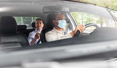 Image showing male driver in mask driving car with passenger