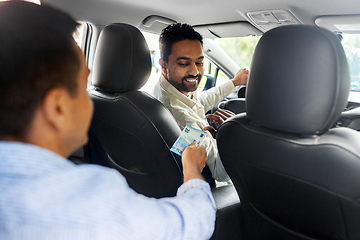 Image showing passenger giving money to smiling taxi car driver