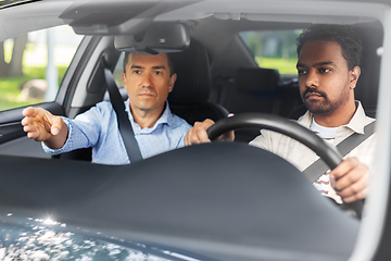 Image showing car driving school instructor teaching male driver