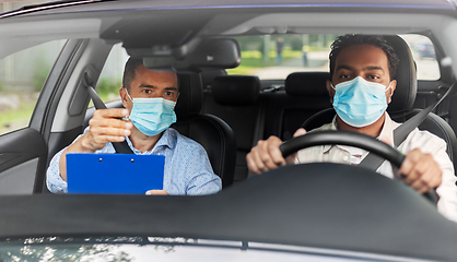 Image showing car driving school instructor and driver in mask