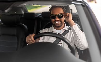 Image showing smiling indian man in sunglasses driving car