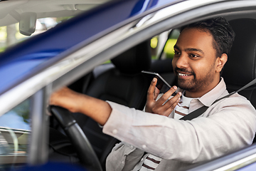 Image showing man driving car and recording voice by smartphone