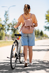 Image showing woman with bicycle and backpack walking in city